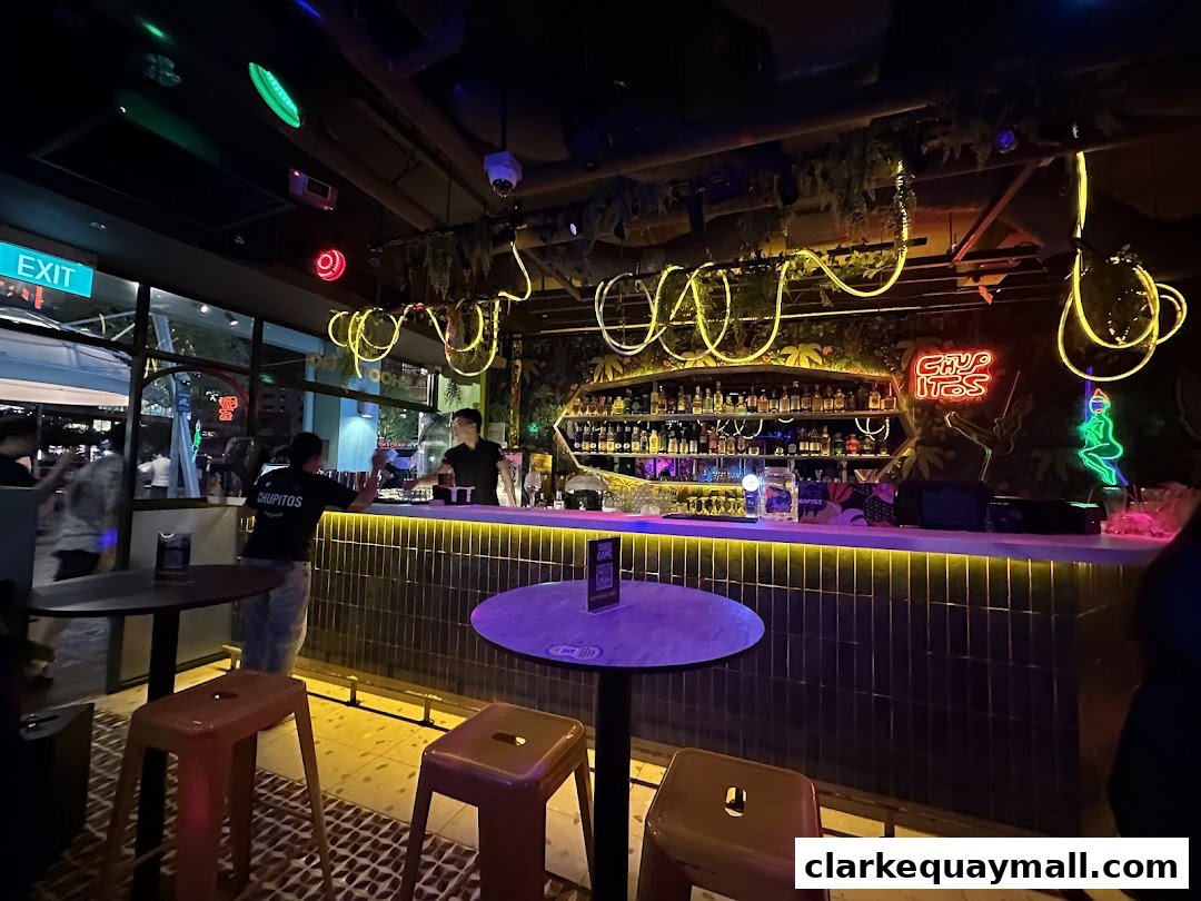 A lively bar interior with a bartender serving drinks at a well-stocked bar.