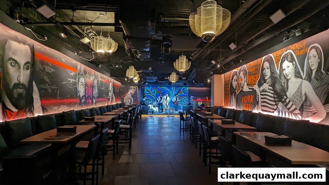 Interior of a stylish bar with band performing on stage and artistic murals on the walls.
