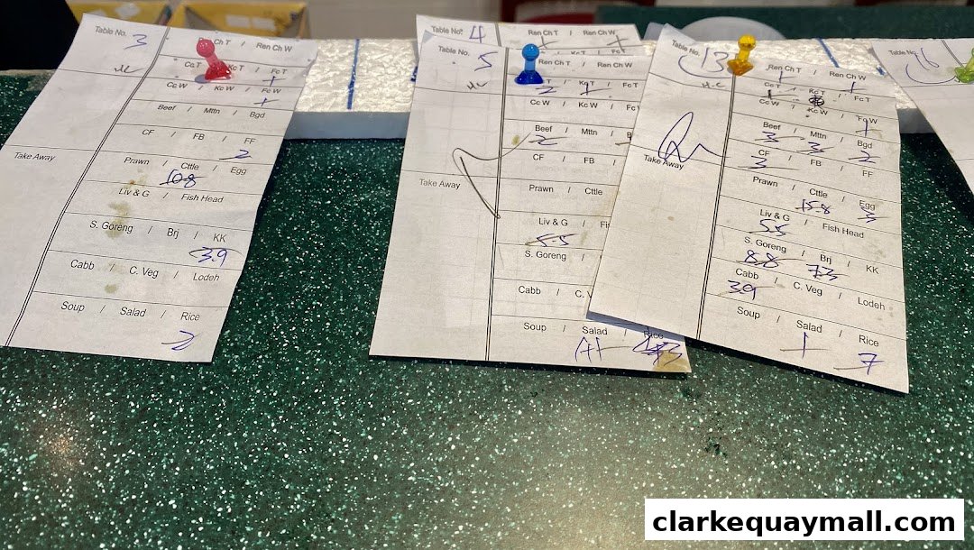 Close-up of handwritten order slips with food items and table numbers.