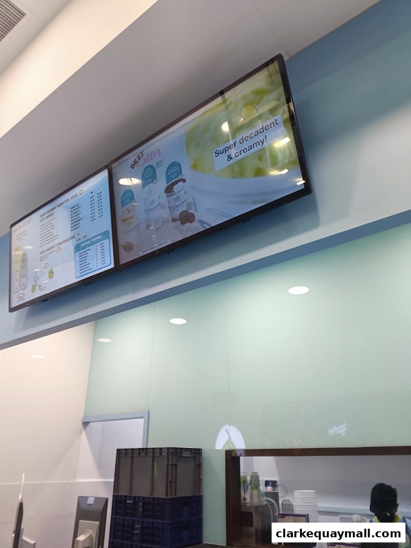 Digital menu boards displaying beverage options and promotional images for Mr. Coconut.