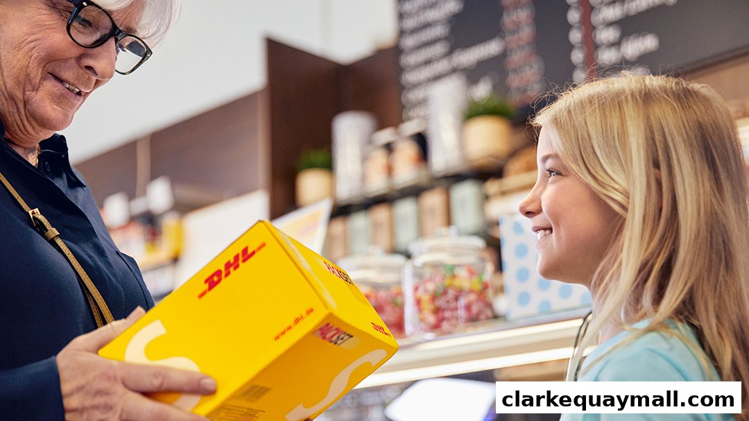 A woman hands a DHL package to a smiling child in a store.