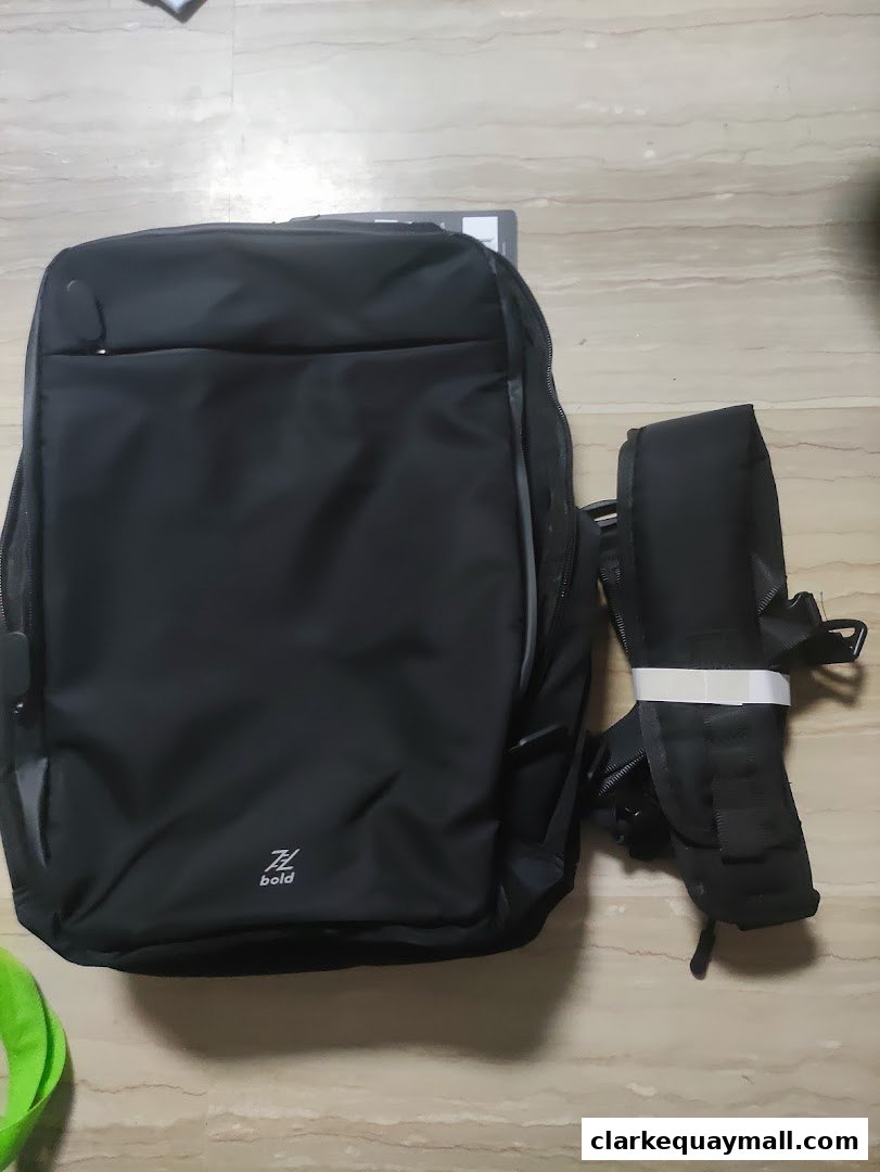 A black backpack and a smaller black bag with straps are displayed on a tiled floor.