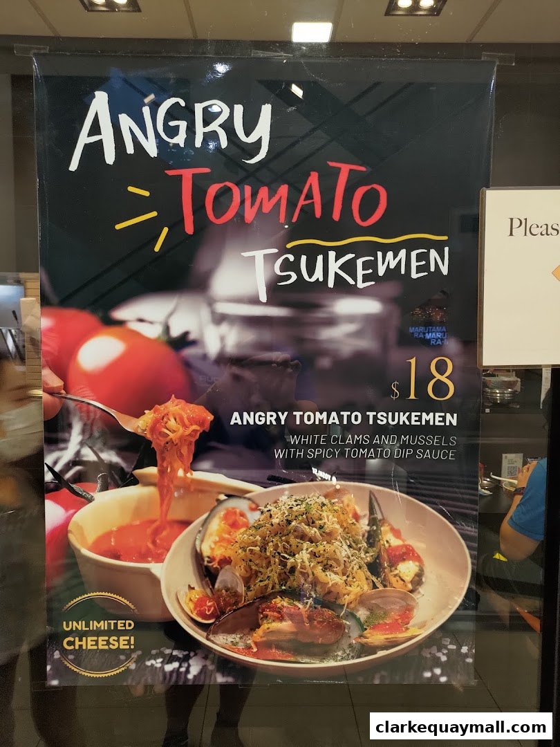 A poster advertising Marutama Ramen's Angry Tomato Tsukemen with unlimited cheese.
