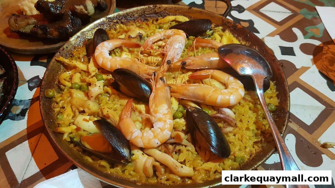 A close-up of a seafood paella dish with shrimp, mussels, and rice, served in a traditional pan.