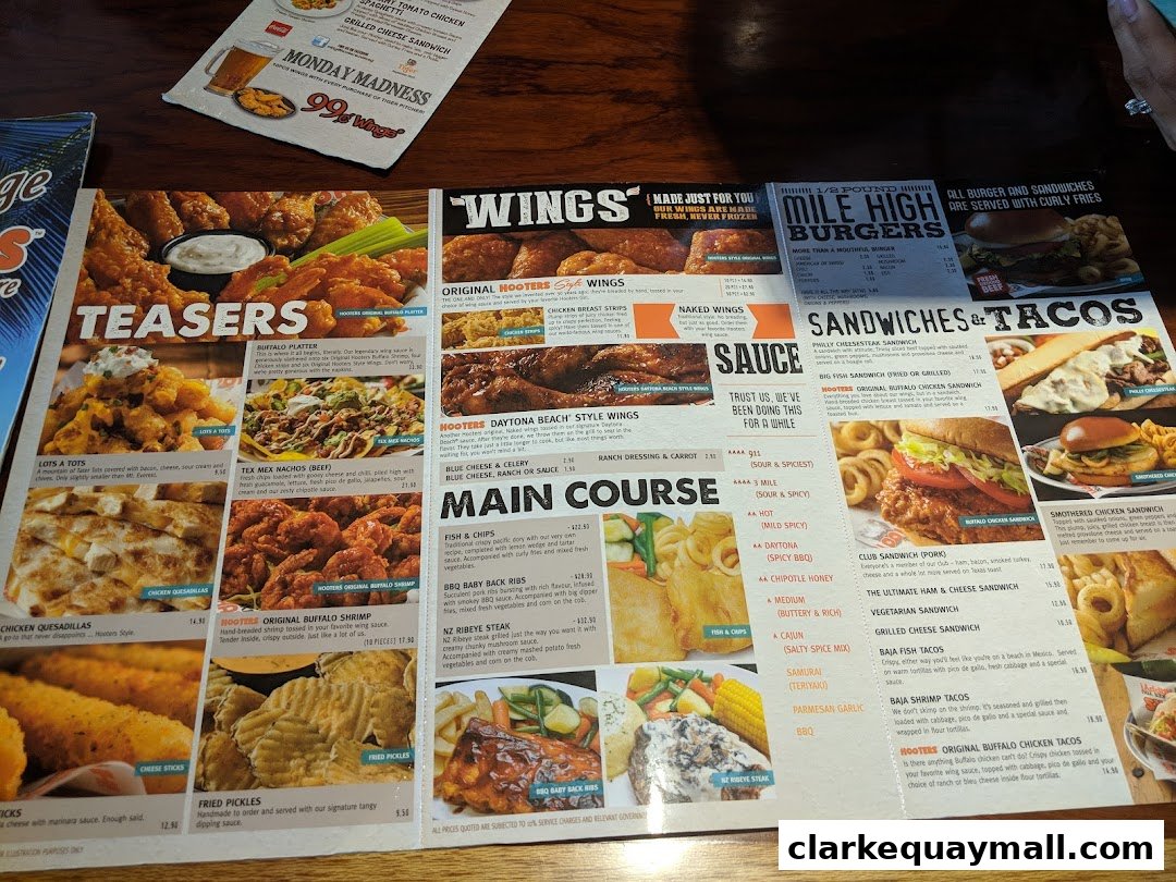 A Hooters menu featuring wings, burgers, sandwiches, tacos, and main courses with prices.