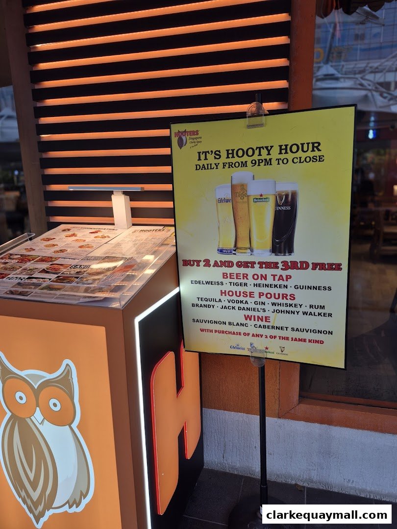 Hooters Singapore advertises its 'Hooty Hour' with beer and house pour specials.