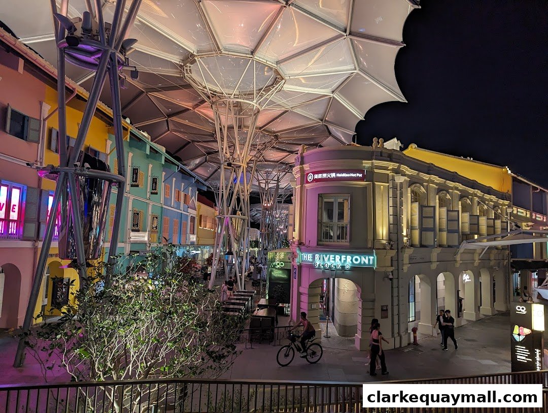 A vibrant street scene at night with colorful buildings and outdoor seating.
