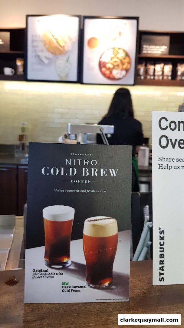 A sign advertising Starbucks Nitro Cold Brew coffee with two glasses of the drink.