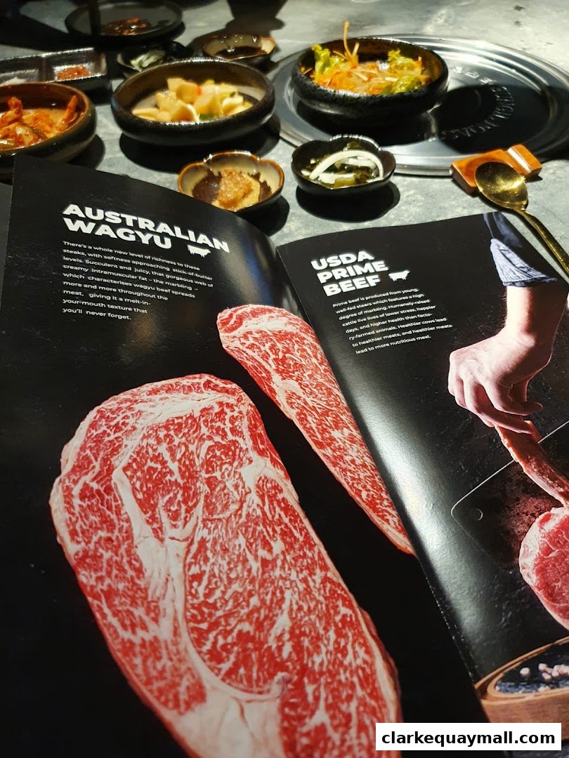 A table setting at Hanjip Korean Grill House with a menu showcasing Australian Wagyu and USDA Prime Beef.