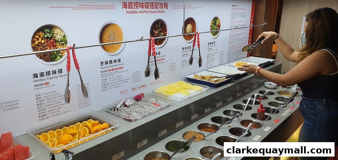 A person selects ingredients from a sauce bar at Haidilao Hot Pot.
