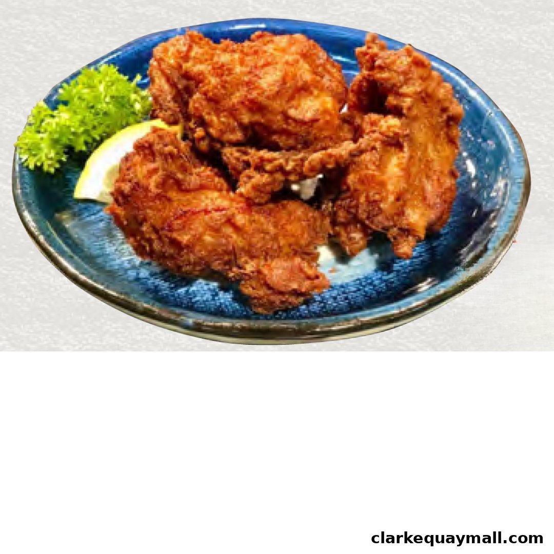 A blue plate with crispy fried chicken pieces, a lemon wedge, and parsley garnish.