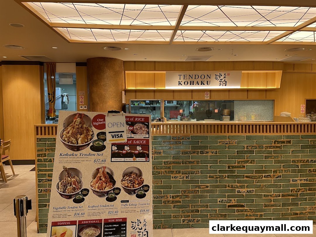 A menu board displays various tendon sets and side dishes outside Tendon Kohaku.