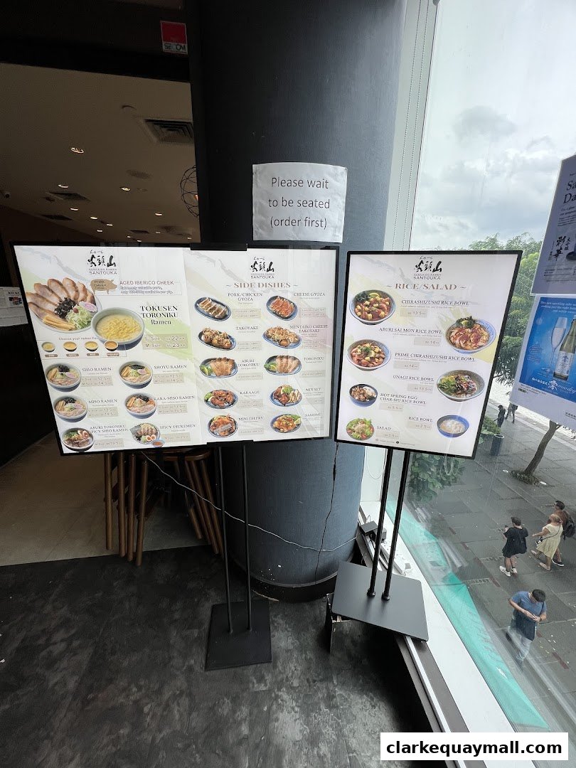 Digital menus displaying ramen, side dishes, and rice bowls at Hokkaido Ramen Santouka.