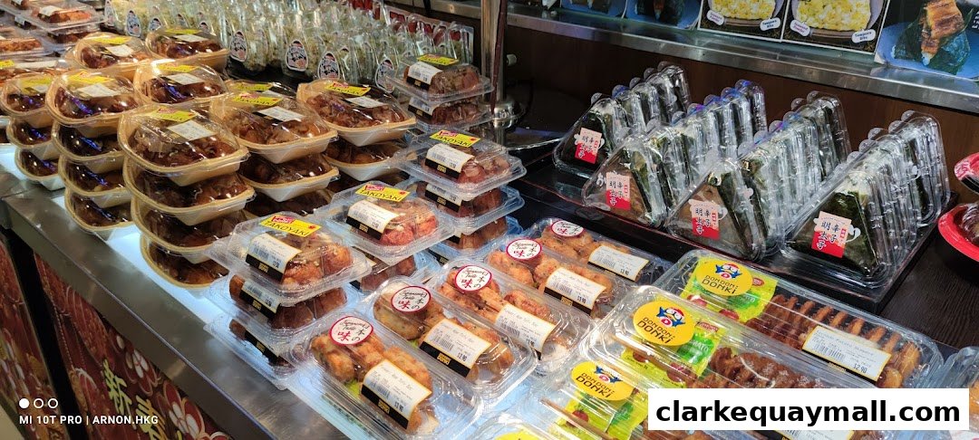 A display of pre-packaged Japanese snacks and meals, including takoyaki and onigiri.