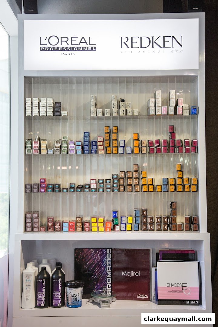 Display shelves stocked with L'Oréal and Redken hair color products and styling supplies.