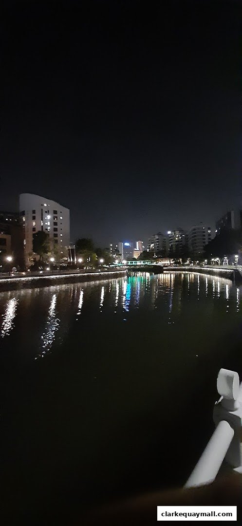 A nighttime view of a river with illuminated buildings and reflections.