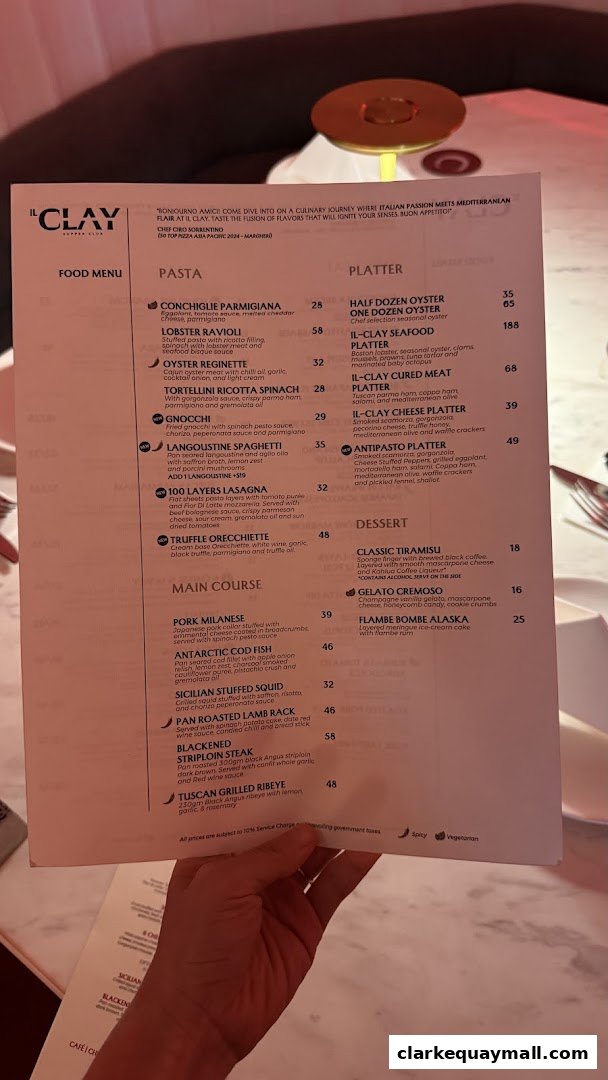 A person holding a menu from IL CLAY Supper Club, featuring Italian and Mediterranean dishes.