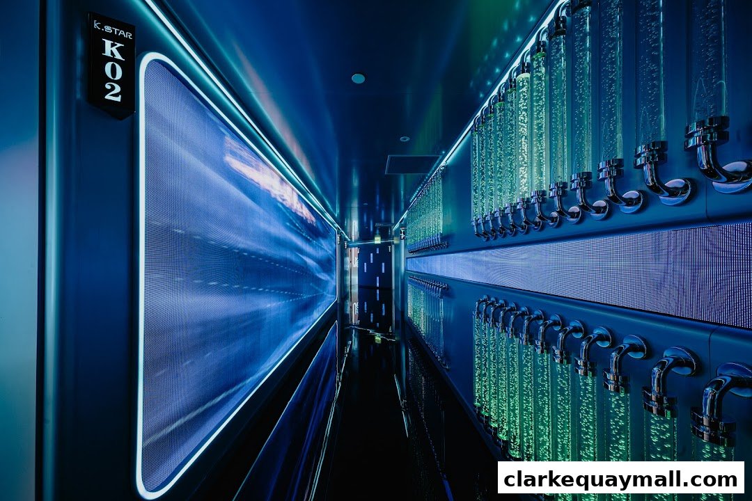 A futuristic hallway with glowing blue screens and rows of illuminated beverage dispensers.