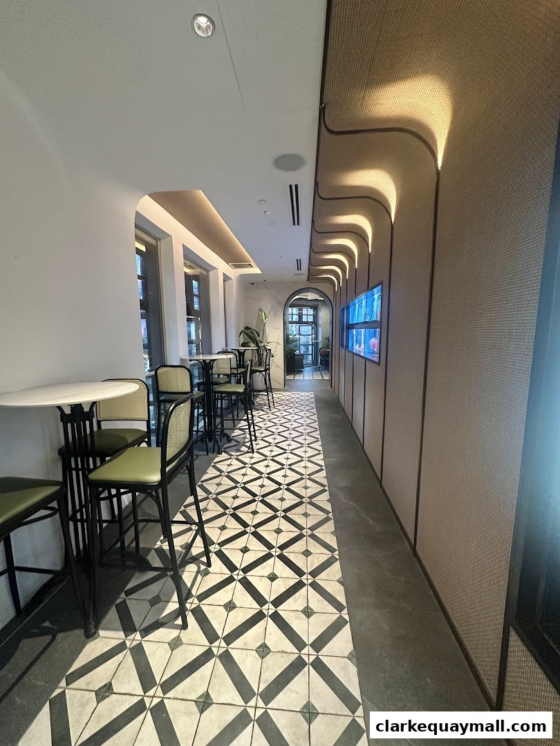Interior view of a modern restaurant with high tables, chairs, and decorative lighting.