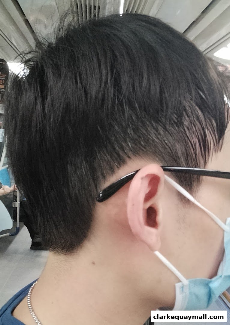 Close-up of a person's ear and haircut, with a mask and glasses.