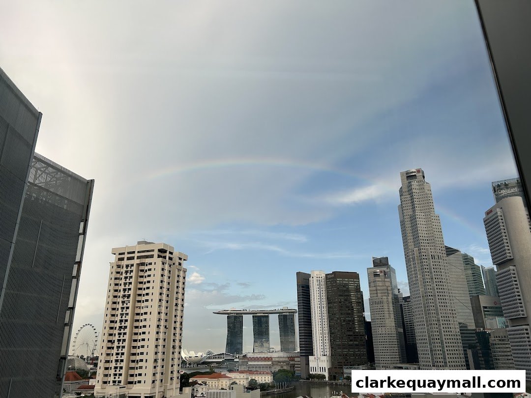 A cityscape view with skyscrapers and a rainbow in the sky.