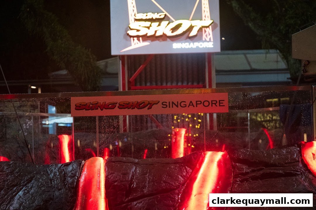 The Slingshot Singapore attraction with its illuminated sign and fiery red display.