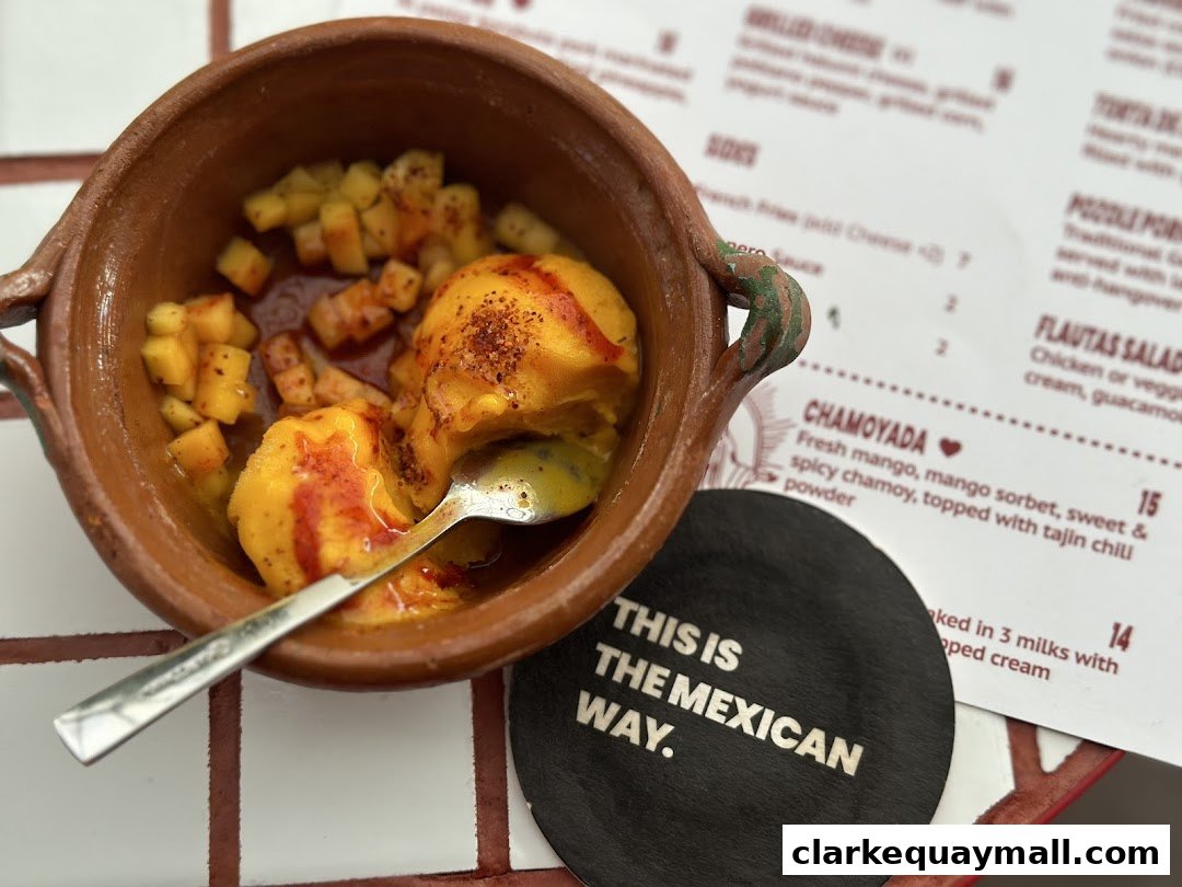 A close-up of a dessert in a clay bowl with a menu and coaster in the background.