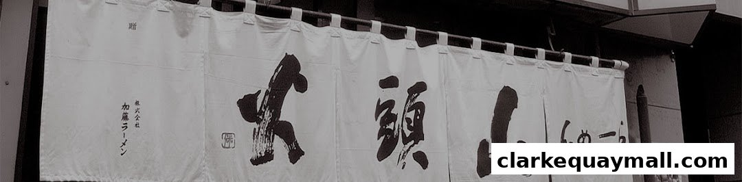 A white noren curtain with Japanese calligraphy advertising Hokkaido Ramen Santouka.