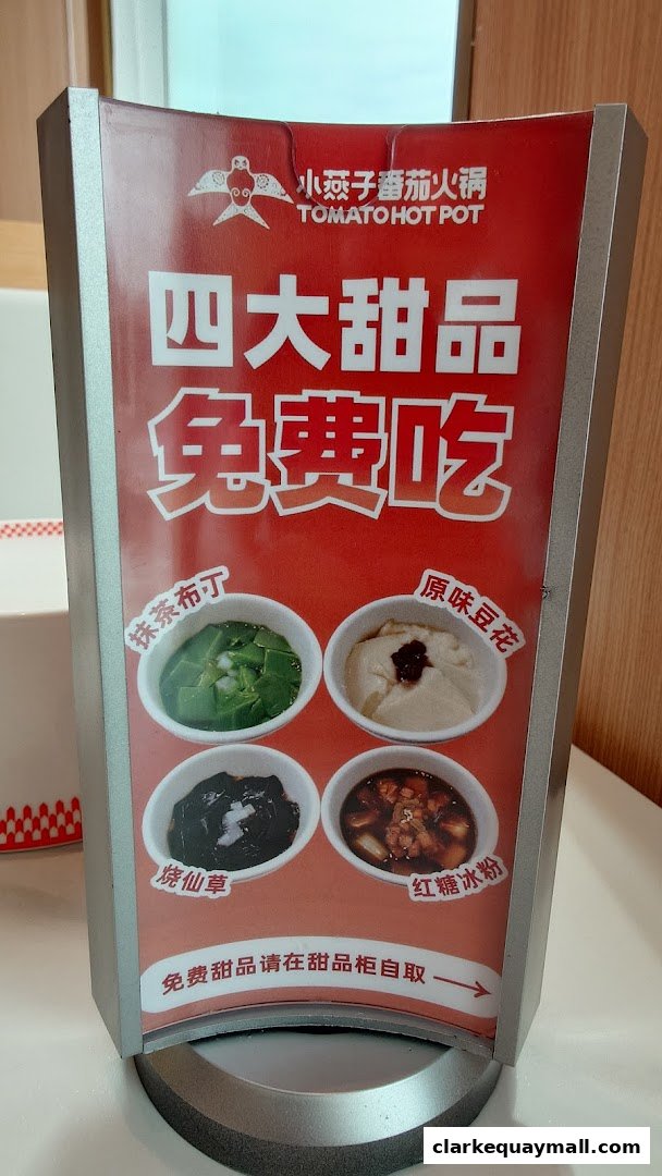 A sign advertising four free desserts from XiaoYanZi Tomato Hot Pot.