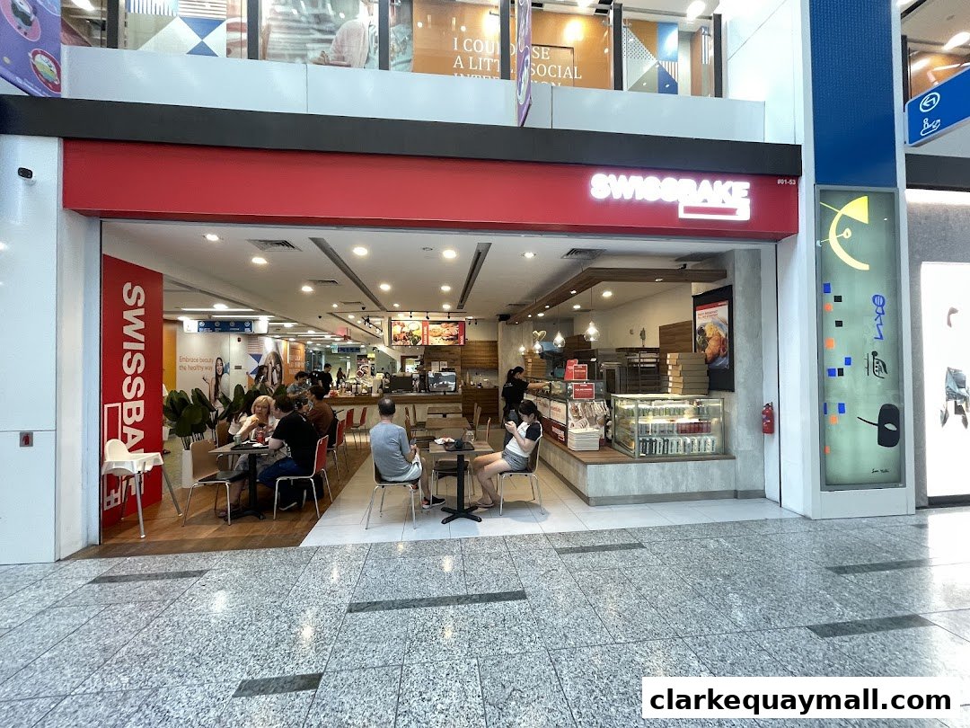 The exterior of Swissbake Cafe with customers seated inside and outside.