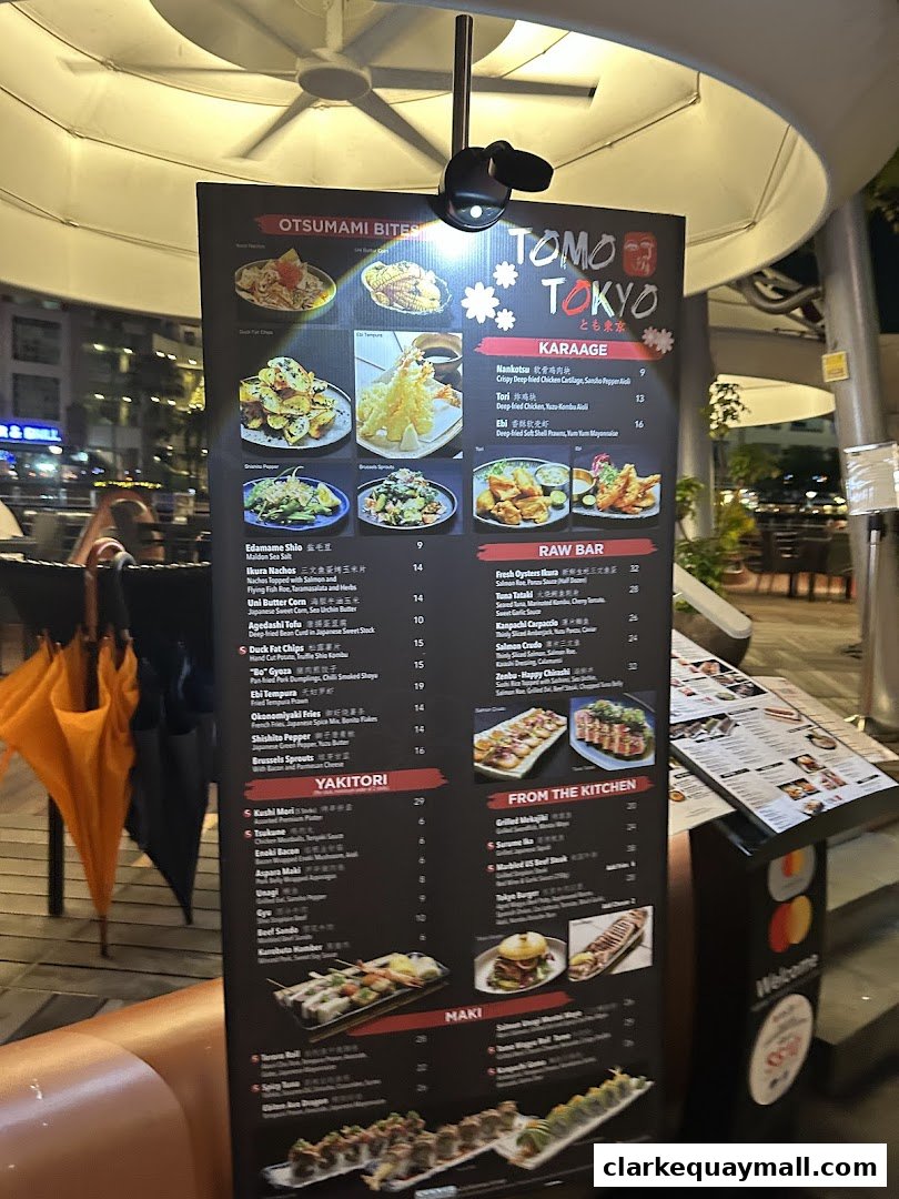 A menu board for Tomo Tokyo, showcasing various Japanese dishes with images.