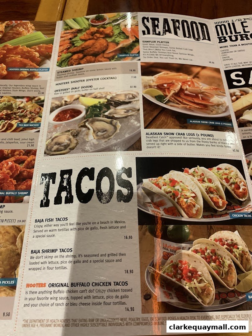 A menu from Hooters featuring seafood and tacos, with vibrant food photography.