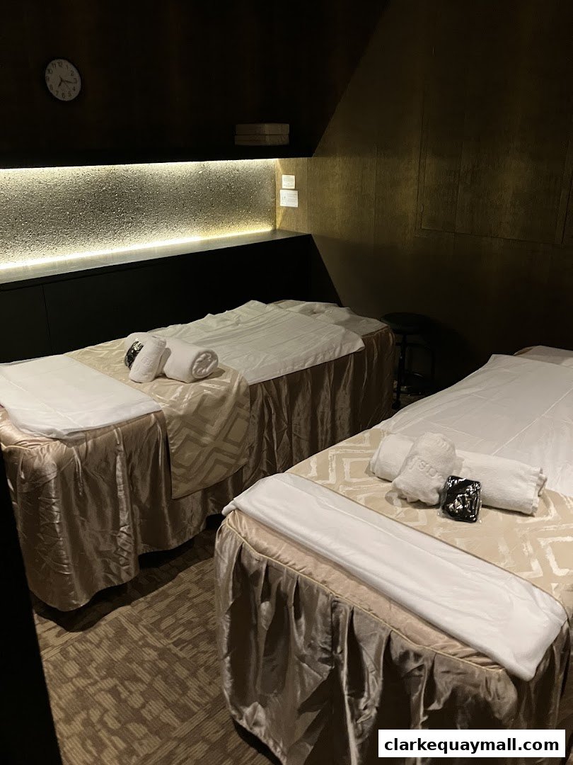 Two massage beds are set up in a dimly lit, luxurious spa room.