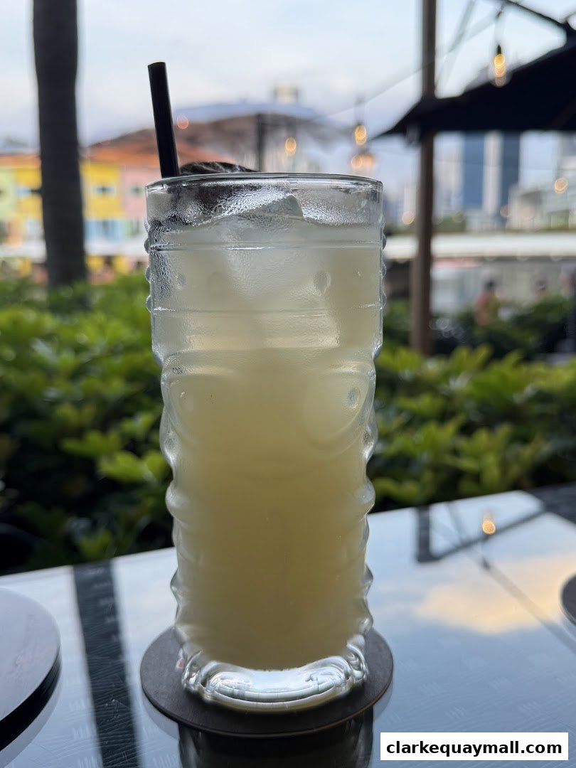 A refreshing cocktail served in a tiki-style glass on a table with a blurred background.