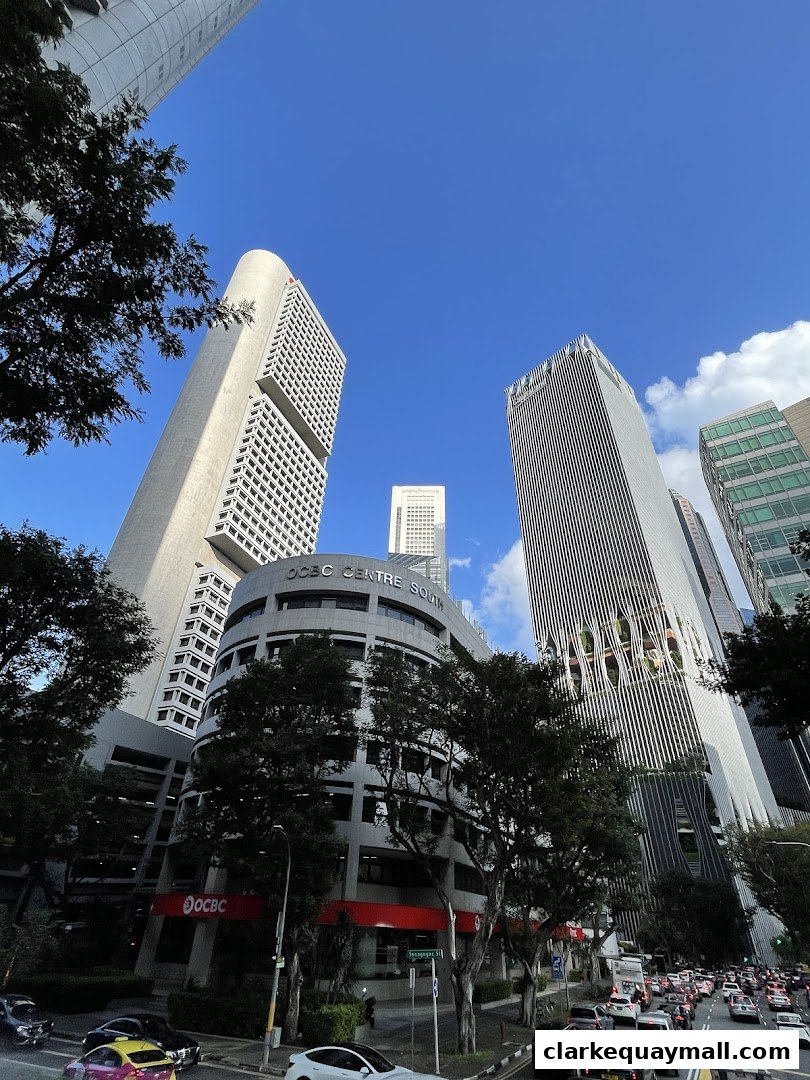 A low-angle shot of modern skyscrapers against a clear blue sky with some clouds.
