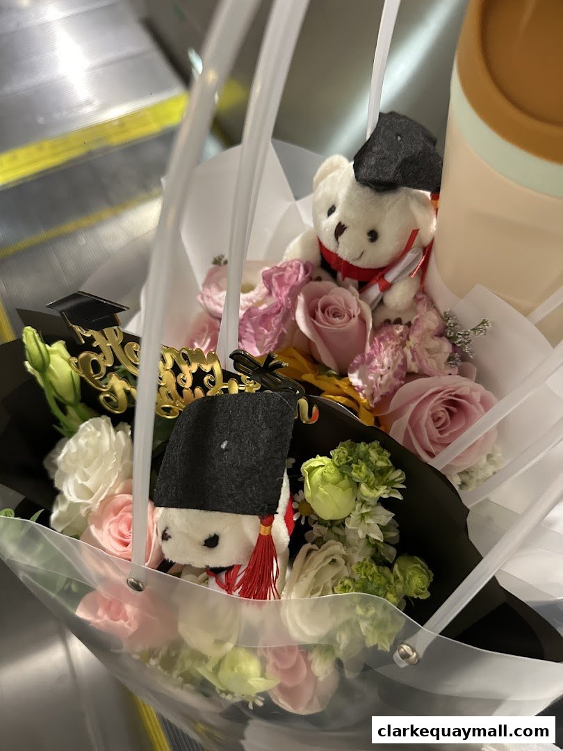 A bouquet of flowers with graduation-themed teddy bears and decorations.