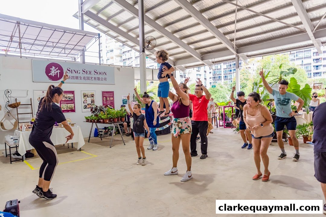 People participating in a fitness class with plants and signage in the background.