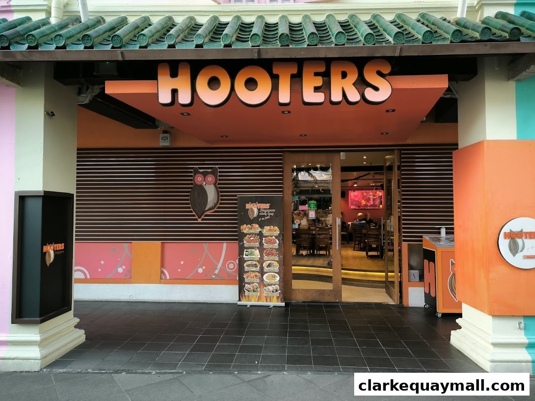 The exterior of a Hooters restaurant with its prominent orange signage and entrance.