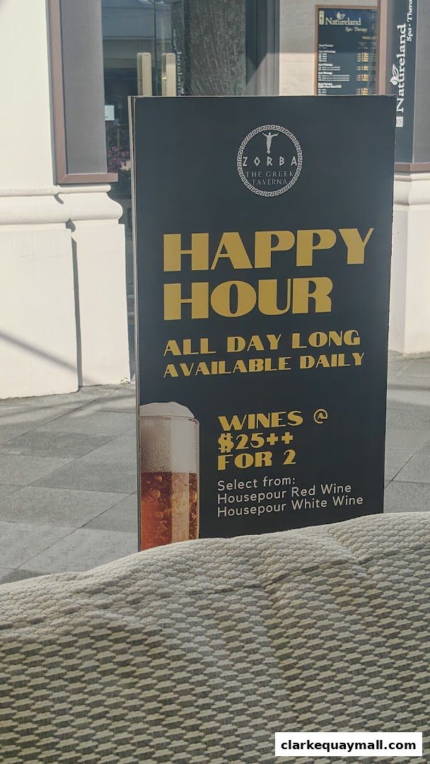 A sign advertising Zorba The Greek Taverna's happy hour with wine specials.