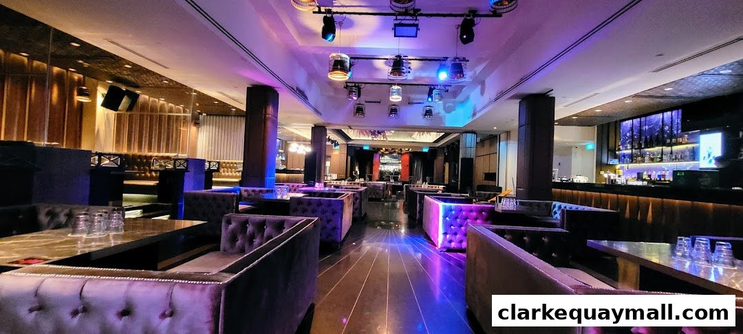 Interior view of a modern nightclub with plush seating, a bar, and ambient lighting.