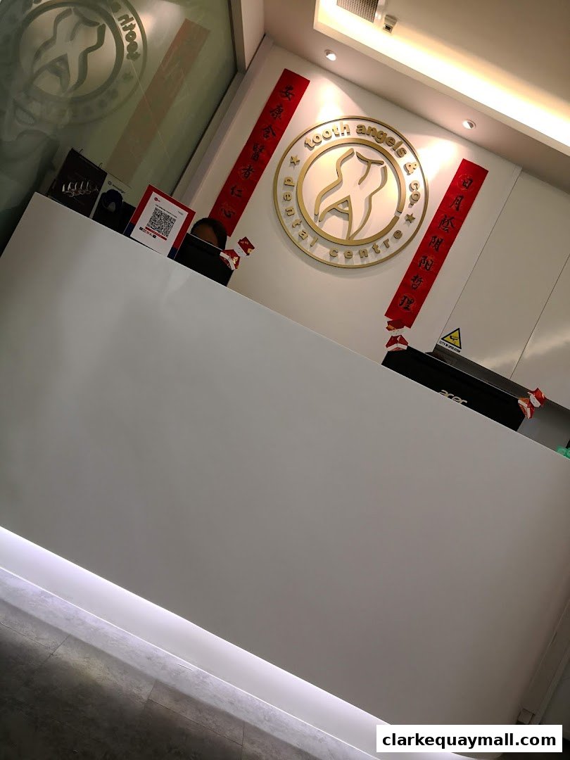The reception area of Tooth Angels Dental Centre with a modern white counter and the clinic's logo.
