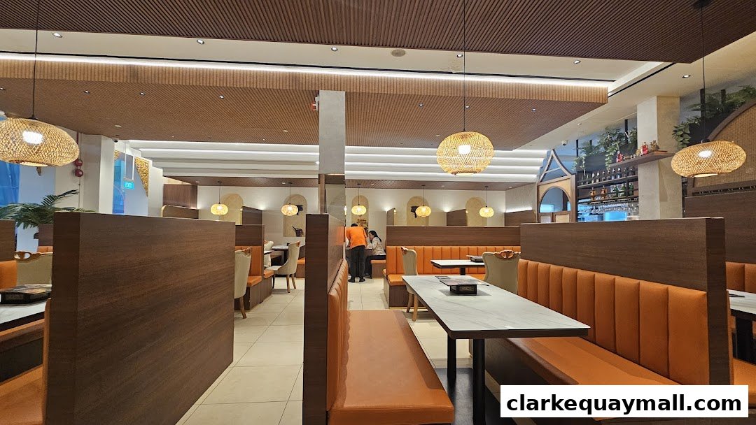 Interior view of a Thai restaurant with orange booth seating and wooden accents.