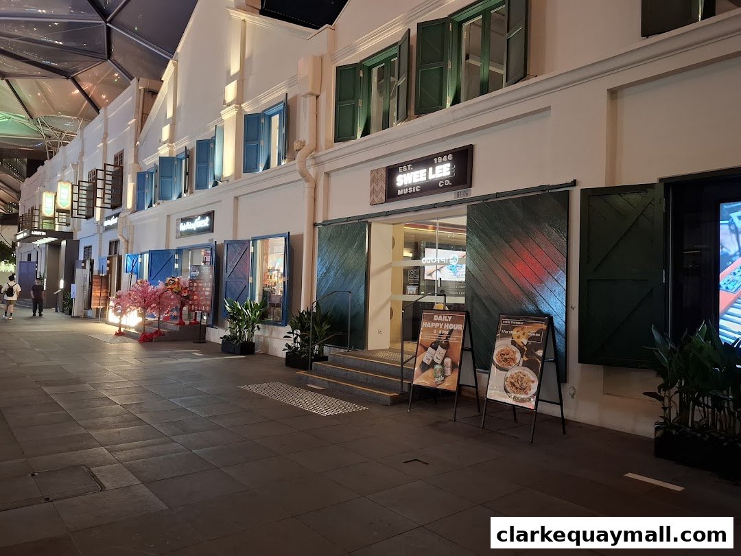 The exterior of Swee Lee Music Co. at Clarke Quay, with open doors and promotional signs.