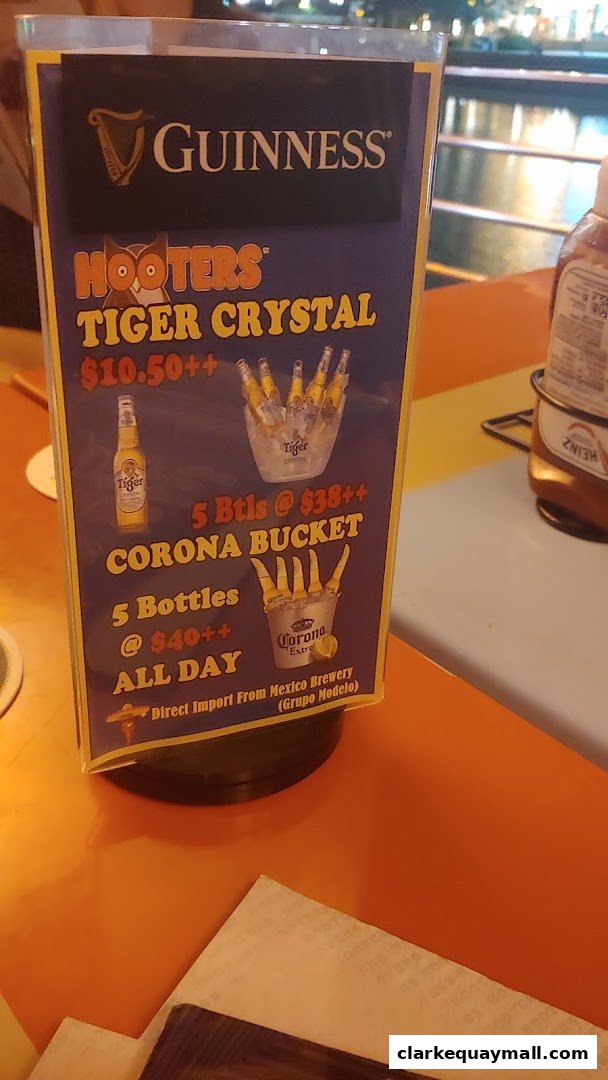 A Hooters menu board advertising Tiger Crystal and Corona beer specials.