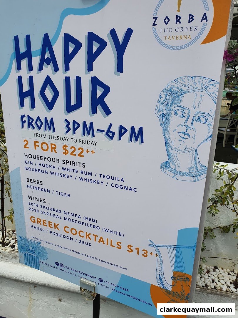 A sign advertising happy hour specials at Zorba The Greek Taverna with drink options and prices.