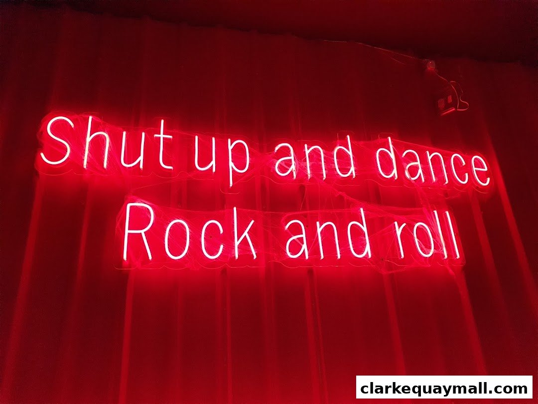 Red neon sign with the text "Shut up and dance Rock and roll".