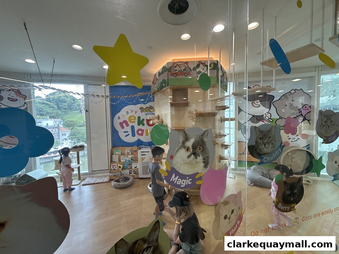 Interior of a cat cafe with children interacting with cat-themed decor and play structures.