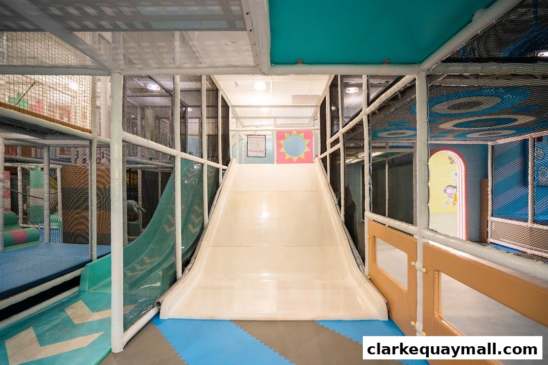 Interior view of a colorful indoor playground with a large slide and soft play structures.