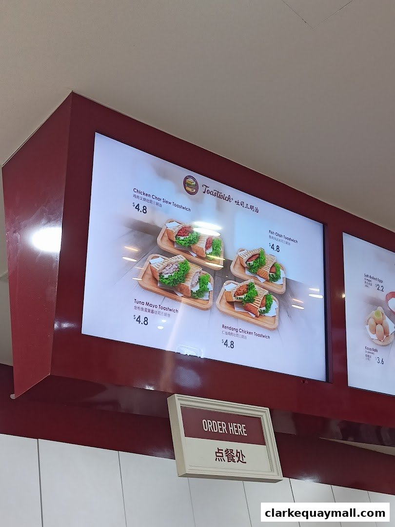 A digital menu board displaying various toastwich options and prices at Ya Kun Kaya Toast.