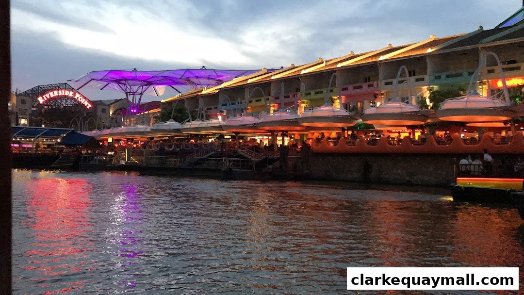 A waterfront view of Riverside Point with illuminated buildings and a river reflecting colorful lights.